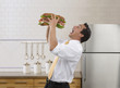 Pacific Islander businessman eating large sandwich
