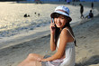 Little Chinese Asian girl on beach with phone