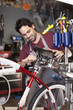 Hispanic man assembling bicycle in shop