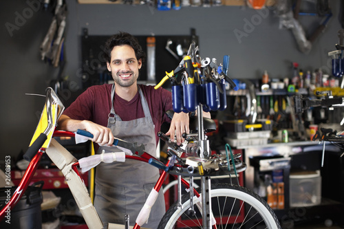 Photo: Hispanic man assembling bicycle in shop Hispanic man assembling bicycle in shop