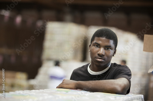 Photo: Black man standing in warehouse Black man standing in warehouse
