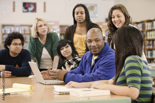 Photo: Librarian helping students in school library Librarian helping students in school library