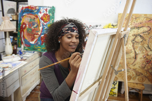 Photo: Mixed race artist painting in studio Mixed race artist painting in studio