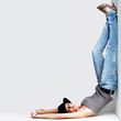 Upside down - Cute young woman with legs up against a wall