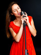 Young female jazz singer singing with retro mic