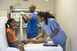 Doctor and nurse helping girl with injured leg