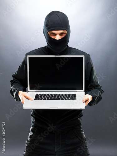 Photo: Computer hacker - Robber stealing information from laptop Computer hacker - Robber stealing information from laptop