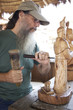 Mixed race man carving wooden statue