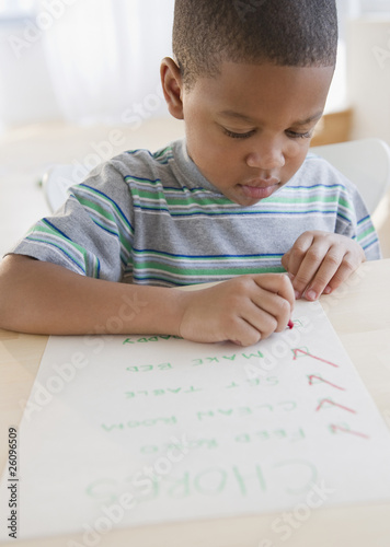 Photo: African American boy checking list of chores African American boy checking list of chores