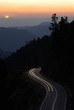 car travelling winding road between mountain at sunset car travelling winding road between mountain at sunset