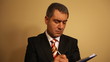 Businessman writing document on clipboard