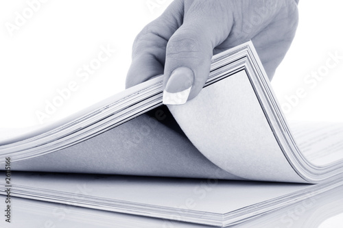 Photo: hand browsing through stack of magazines hand browsing through stack of magazines