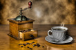 Coffee grinder with a cup of steaming coffee