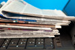 Stack of newspapers on laptop Stack of newspapers on laptop