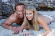 Photo: Couple embrace, lying down, lean on Rocks in a Bay Couple embrace, lying down, lean on Rocks in a Bay