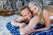 Photo: Couple embrace, lying down, lean on Rocks in a Bay Couple embrace, lying down, lean on Rocks in a Bay