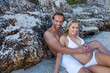 Photo: Couple embrace, lying down, lean on Rocks in a Bay Couple embrace, lying down, lean on Rocks in a Bay