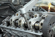 Socket wrench and camshaft of  car engine in close up
