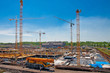 Construcion site with several yellow cranes