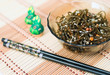 Photo: Laminaria salad with chopsticks over bamboo mat Laminaria salad with chopsticks over bamboo mat