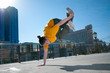 Teenage hip-hop girl dancing over city landscape