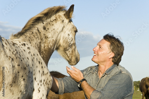 Photo: happy man petting his horse happy man petting his horse