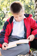 Serene kid reading book in park