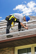 Photo: Man working on roof installing rails for solar panels Man working on roof installing rails for solar panels