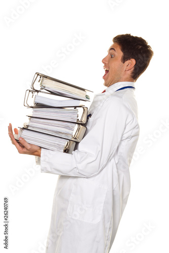 Foto: Arzt im Stress mit Akten Stapel. Bürokratie im Krankenhaus. Arzt im Stress mit Akten Stapel. Bürokratie im Krankenhaus.