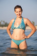 Pretty young laughing woman standing in the sea