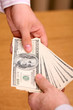 Two businessmen giving and taking dollars