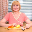 A happy middle-aged woman cooking meal