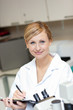 Friendly female scientist writing on a clipboard Friendly female scientist writing on a clipboard