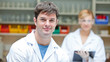 Two concentrated scientists looking at the camera standing