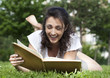 jeune fille riant en lisant un livre
