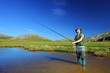 Happy fisherman fishing at lake with mountains in the background Happy fisherman fishing at lake with mountains in the background