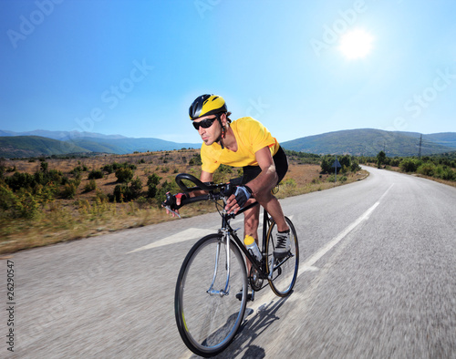 Photo: Cyclist riding a bike on an open road Cyclist riding a bike on an open road