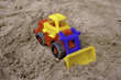 Plastic toy tractor on the sand Plastic toy tractor on the sand