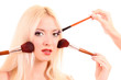Beautiful young blonde woman with bright make-up and many brushe Beautiful young blonde woman with bright make-up and many brushe