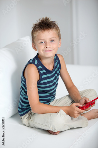 Photo: Little boy playing video games on sofa Little boy playing video games on sofa