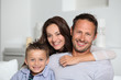 Closeup of parents and child relaxing at home on sofa