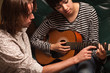 Young Musician Teaches Female Student To Play the Guitar Young Musician Teaches Female Student To Play the Guitar