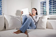 Photo: Hispanic woman using tablet computer on couch Hispanic woman using tablet computer on couch