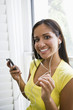 Photo: Hispanic woman listening to music on mp3 player Hispanic woman listening to music on mp3 player