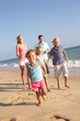 Portrait Of Running Family On Beach Holiday