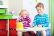 Kids sitting together at table drawing