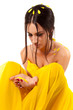 Attractive young brunette woman with yellow flower in hands