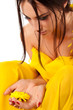 Attractive young brunette woman with yellow flower in hands