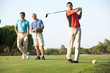 Group Of Male Golfers Teeing Off On Golf Course