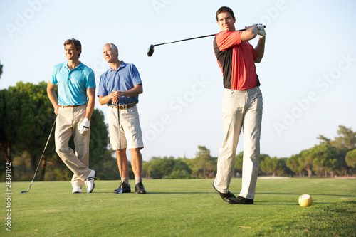 Photo: Group Of Male Golfers Teeing Off On Golf Course Group Of Male Golfers Teeing Off On Golf Course